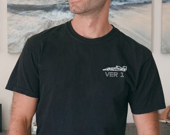 May include: A black t-shirt with a white graphic of a race car and the text "VER 1" on the front.