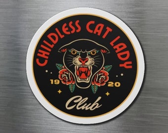 May include: A round black and white magnet with the text "Childless Cat Lady Club" in red and gold lettering. The magnet features a black panther with red roses and a gold star.