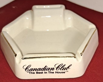 Cendrier vintage en porcelaine de la marque Canadian Club intégré dans le support d'allumettes. Très bon état. Garniture dorée sans éclats ni dommages. Livraison gratuite