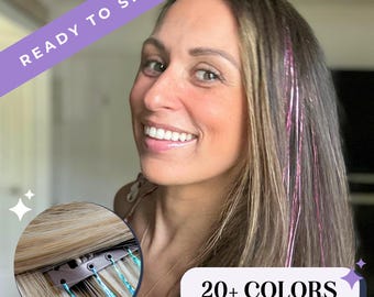 May include: Hair tinsel strands in vibrant pink and blue colors attached to hair with small metal clips. The image features text overlays stating READY TO SHIP and 20+ COLORS, showcasing the product applied to long brown hair.