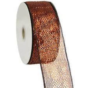 May include: A roll of copper-colored metallic mesh ribbon. The ribbon is on a white spool with a black center.