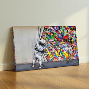 Op de afbeelding: Canvas print met een kind dat een gordijn opzijtrekt om een levendige graffiti-muurschildering te onthullen. Het kunstwerk toont een grijswaarde kinderfiguur in contrast met een kleurrijke explosie van graffiti-kunst.