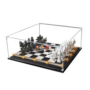 May include: A LEGO brick-built chess set enclosed in a clear acrylic display case. The board features alternating black and white squares with black and white molded plastic chess pieces. Three small character minifigures stand on the board.