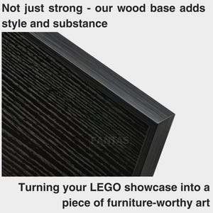 Pu&ograve; includere: Una base in legno nero con una texture a grana visibile, che presenta il testo "Not just strong - our wood base adds style and substance" in alto e "Turning your LEGO showcase into a piece of furniture-worthy art" in basso.