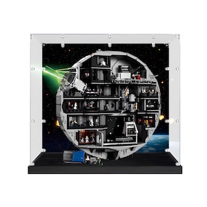May include: A spherical space station building block set displayed inside a clear acrylic case. The structure features multiple interior levels with various rooms, miniature figures, and a green laser beam projecting from a dish on the side.