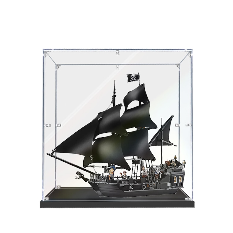 May include: A black pirate ship model with black sails and a skull and crossbones flag, displayed in a clear acrylic case. The ship has detailed features, including masts, rigging, and figures on deck. The model is set on a black base.