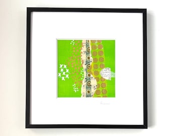May include: A framed green and gold abstract collage with white and pink accents. The collage features a piece of sheet music and gold dots. The piece is signed "Aimee".