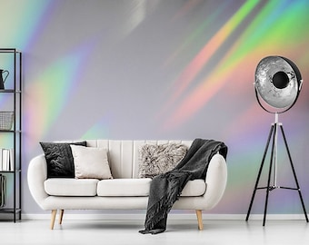 May include: A white couch with black and white pillows sits in a living room with a black and white patterned rug. A black tripod floor lamp with a silver reflector is in the corner of the room. The wall behind the couch is painted a light gray with a rainbow iridescent pattern.
