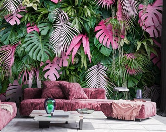 May include: A pink and green tropical leaf wall mural with a burgundy velvet sofa and a throw blanket. The sofa is in front of the wall mural and there is a coffee table in front of the sofa.