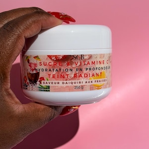 May include: A white plastic jar of skincare cream with a label featuring a strawberry daiquiri graphic and the text SCB SUCRE & VITAMINE C HYDRATATION EN PROFONDEUR TEINT RADIANT SAVEUR DAIQUIRI AUX FRAISES 250 g, with a smooth white screw-on lid.