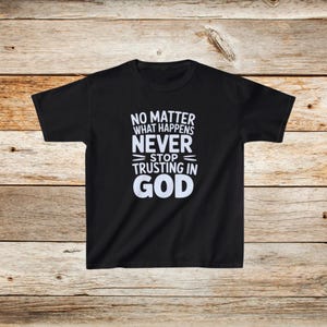 Op de afbeelding: Zwart T-shirt met witte tekst die "No matter what happens never stop trusting in God" zegt.