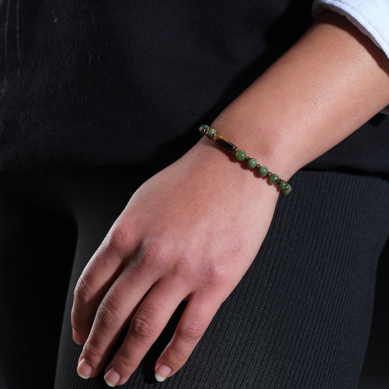 A crystal bracelet that can be preferred as a summer stone for women or as a special day gift by adding real jade stone on the woman's wrist and a cylindrical tiger's eye stone in the middle decorated with steep yellow hematite stones.