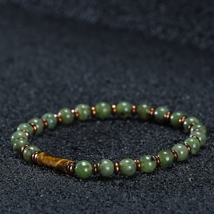 A bracelet with 6mm jade stone and yellow hematite stone on a black background, which can be bought as a gift for the boyfriend