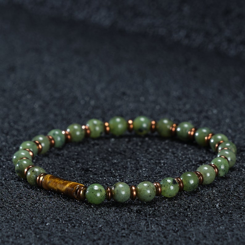 A bracelet with 6mm jade stone and yellow hematite stone on a black background, which can be bought as a gift for the boyfriend