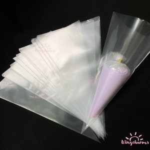 May include: A stack of clear plastic piping bags, with one bag filled with purple frosting. The bags are designed for decorating cakes and other desserts.