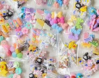 Puede incluir: Una colección de abalorios de resina coloridos en varias formas, incluyendo lazos, flores y personajes de dibujos animados, empaquetados en bolsas de plástico transparente. Algunos abalorios tienen el texto "LOVE YOU" y "RABBIT'S HOUSE".
