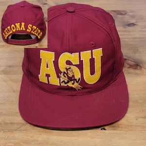 May include: A maroon baseball cap featuring the yellow embroidered letters ASU with a small devil mascot graphic integrated into the letter S. The back of the cap displays the yellow embroidered text ARIZONA STATE above a maroon plastic snapback.