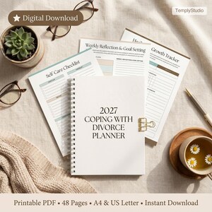 May include: A white 2027 Coping With Divorce Planner with a gold binder clip, surrounded by self-care and goal-setting worksheets. The image includes a succulent, eyeglasses, and a cup of tea with daisies.