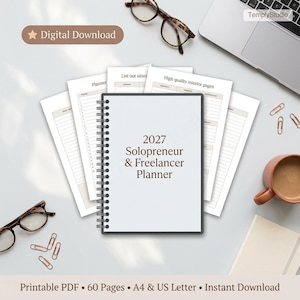 Puede incluir: Un planificador blanco con espiral titulado "2027 Solopreneur & Freelancer Planner" se muestra con hojas sueltas. La imagen incluye gafas, clips, una taza y el texto "Digital Download."