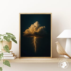May include: Framed art print featuring a dramatic image of a golden cloud illuminated by a vibrant lightning bolt against a dark blue background. The artwork is displayed on a wooden shelf with decorative items.