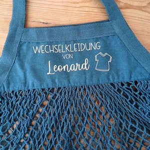 May include: A blue mesh bag with a white label that says "Wechselkleidung von Leonard" and a small graphic of a t-shirt.