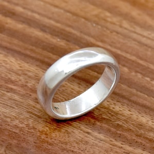 May include: A simple silver band ring with a smooth, polished finish.