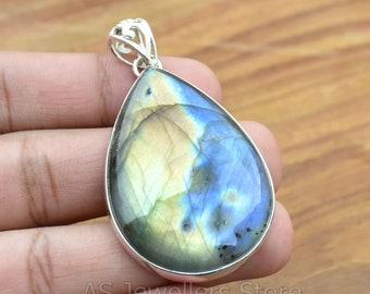May include: A teardrop-shaped pendant with a silver setting and a blue and gold labradorite gemstone.