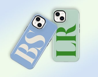 May include: Two phone cases. One is light blue with the letters "BS" in a cream color. The other is light green with the letters "LR" in green. Both cases have a glossy finish and a camera cutout.
