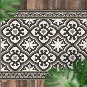 May include: A black, white, and green patterned kitchen rug with a decorative border. The rug has a geometric design with repeating motifs.