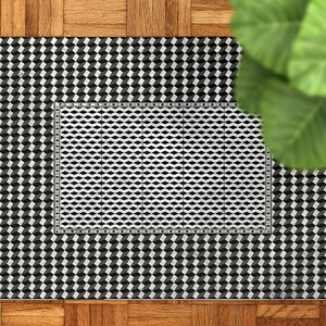 Könnte beinhalten: Schwarz-weißer geometrischer Teppich mit einem kleineren schwarz-weißen Teppich im Inneren. Der Teppich hat ein 3D-Würfeldesign.