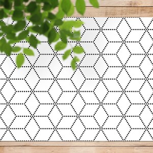 Può includere: Un tappeto geometrico bianco e nero con un motivo esagonale ripetitivo. Il motivo è composto da piccoli punti neri che formano linee.