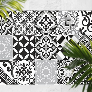 May include: A rectangular surface composed of sixteen square tiles with various black, white, and gray geometric patterns. The designs include floral, diamond, and abstract shapes. The tiles are arranged in a grid, creating a cohesive decorative element.