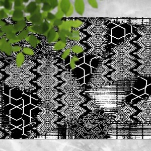 Puede incluir: Alfombra en blanco y negro con un patrón geométrico. La alfombra está compuesta por diferentes secciones con diferentes patrones, incluyendo hexágonos, diamantes y diseños florales.