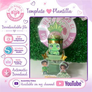 May include: A digital craft template featuring a 3D paper structure with a green frog illustration, a clear dome, and two small character cutouts. The design includes text labels for ZIP, Studio, and SVG files, plus a YouTube assembly video link.
