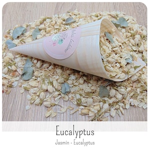 May include: A cone-shaped wooden container filled with dried jasmine flowers and small eucalyptus leaves. A round pink sticker on the cone features the text "P&eacute;tales boh&egrave;me". Additional dried jasmine and eucalyptus are scattered around.