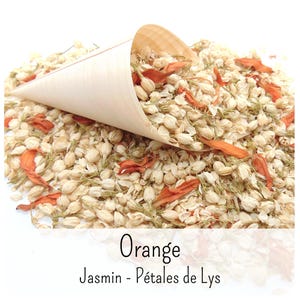 May include: A light-coloured wooden cone filled with a mixture of dried white jasmine buds and vibrant orange flower petals. The text Orange Jasmin - P&eacute;tales de Lys is printed in black at the bottom of the image, describing the botanical contents.