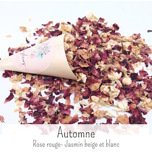 May include: A tan paper cone filled with dried red rose petals and white jasmine flowers. The cone features a pink circular label with a line art illustration and the text "fleurs". The text "Automne Rose rouge- Jasmin beige et blanc" is below.