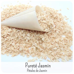 May include: A light beige wooden cone filled with and resting on a pile of dried, off-white jasmine petals. The text Puret&eacute; Jasmin P&eacute;tales de Jasmin is printed in black at the bottom of the image against a white background.