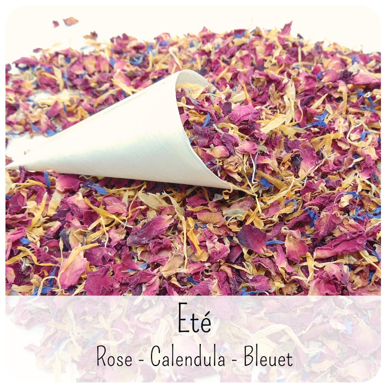 May include: A white paper cone filled with a mixture of dried flower petals, including deep pink rose, yellow calendula, and bright blue cornflower. The text at the bottom reads Et&eacute;, Rose - Calendula - Bleuet, describing the floral blend.