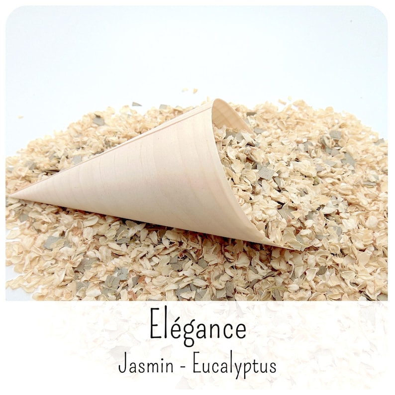 May include: A light-coloured wooden cone filled with a mixture of dried jasmine petals and small green eucalyptus leaves. The text "El&eacute;gance" and "Jasmin - Eucalyptus" is printed in black below the cone on a white background.