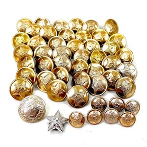 May include: A collection of circular gold-toned metal buttons featuring a raised star design with a hammer and sickle emblem in the centre. The set includes one larger silver-toned circular button and one silver-toned star-shaped metal pin.