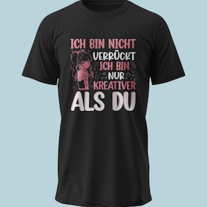 Könnte beinhalten: Ein schwarzes T-Shirt mit kurzen Ärmeln und einer Grafik eines Anime-Charakters mit langen Haaren und Tattoos. Der Text lautet: ICH BIN NICHT VERRÜCKT ICH BIN NUR KREATIVER ALS DU, umgeben von kleinen rosa und weißen Herzumrissen.