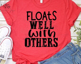 May include: Red t-shirt with a black graphic that says "Floats Well With Others".