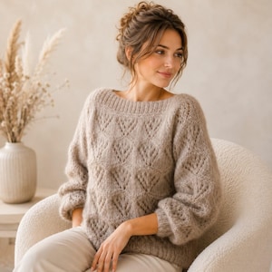 Peut inclure: Un pull beige à manches longues présentant un motif en tricot ajouré en forme de losanges, une large encolure ronde et des poignets côtelés. Le vêtement est confectionné dans un fil doux et duveteux avec une coupe décontractée.