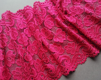 May include: Pink lace trim with a delicate floral pattern. The lace is soft and stretchy, making it perfect for adding a touch of elegance to any project.
