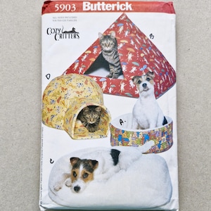 Peut inclure: Un patron de couture pour lits et abris pour animaux de compagnie. Le patron comprend des instructions pour un igloo pour chat, un lit pour chien, une maison pour chat en forme de pyramide et un lit rond. Le patron est étiqueté "5903 Butterick."