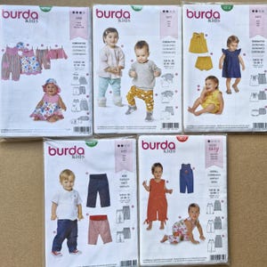 May include: Five Burda Kids sewing pattern envelopes featuring illustrations of children wearing various garments including dresses, jumpsuits, trousers, and shirts. Each white envelope displays the Burda Kids logo, pattern numbers, and technical line drawings of the clothing designs.