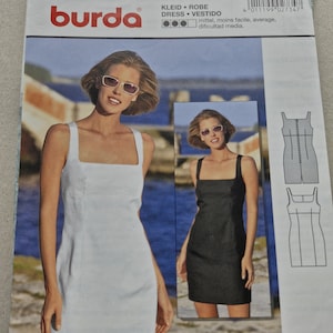 Puede incluir: Un patrón de costura Burda que presenta a una mujer con un vestido blanco de cuello cuadrado y a una mujer con un vestido negro de cuello cuadrado. El patrón incluye diagramas y el logotipo de Burda.