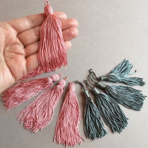 Peut inclure: Un ensemble de franges de garniture rose et gris. Les franges sont faites de fil doux et soyeux et sont parfaites pour ajouter une touche d'élégance à tout projet.