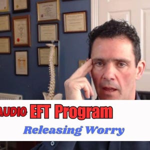 May include: A man in a blue shirt is the focus of this image, with the text "AUDIO EFT Program Releasing Worry" in a white and red banner. The background includes framed certificates and a model of a spine.